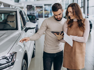 Frau zeigt Mann ein Autoverkauf Angebot auf dem Tablet bei Autoankauf Kempen